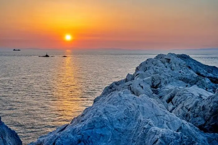 白崎海岸の白い岩肌と海に沈む夕陽
