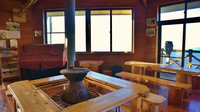 カフェスペースの薪ストーブと木製テーブル